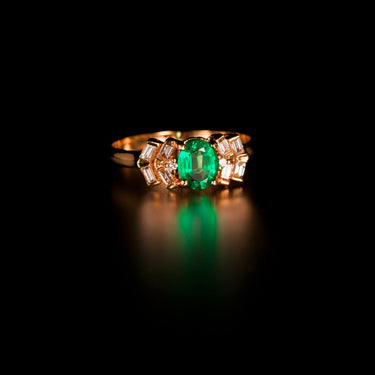 0.63ct natural emerald and diamond ring in 18k yellow gold with brilliant green oval gemstone and baguette diamonds